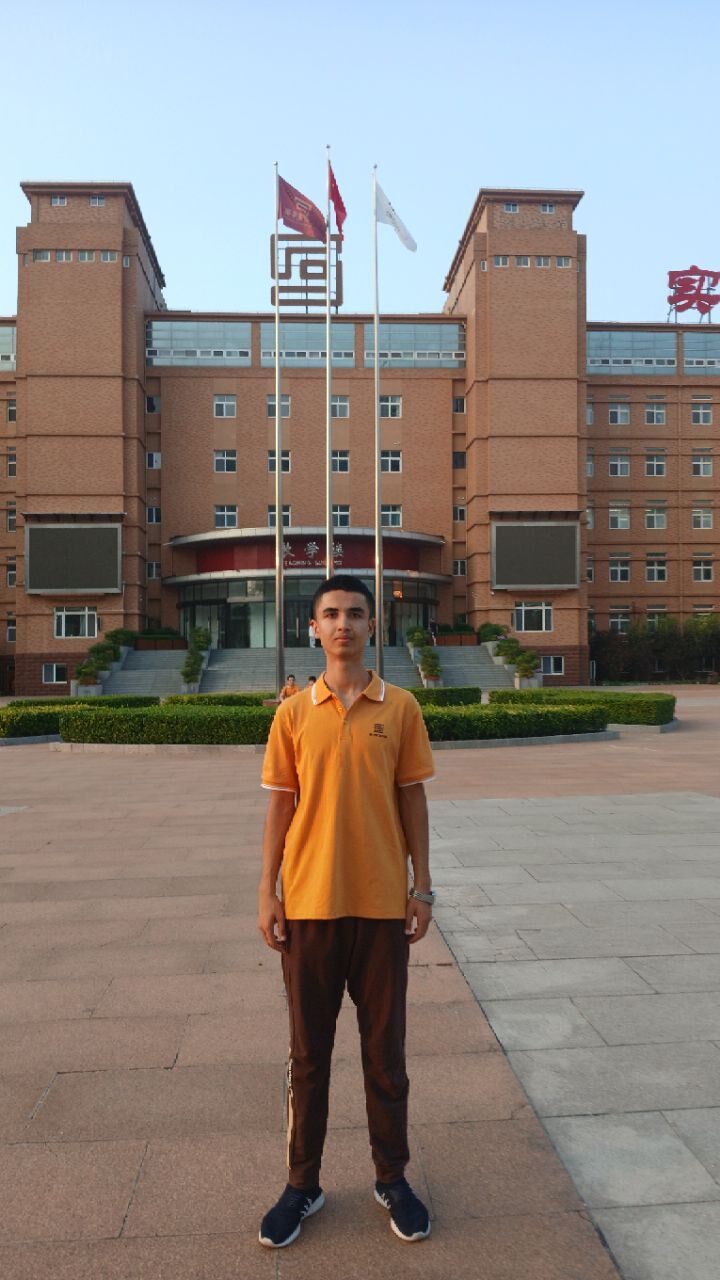 Asliddin standing in front of the Yinghua Academy building